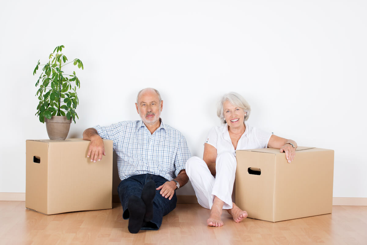 Avail Senior Living | Senior couple sitting with their boxes after downsizing