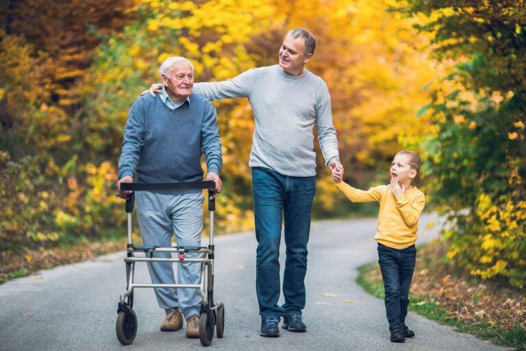 Avail Senior Living | A senior, his son and grandson walking a trail together
