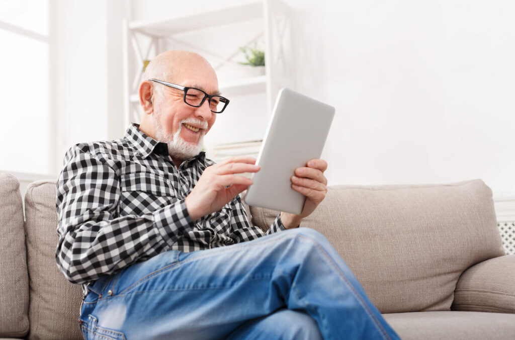Avail Senior Living | Happy senior man reading from his tablet