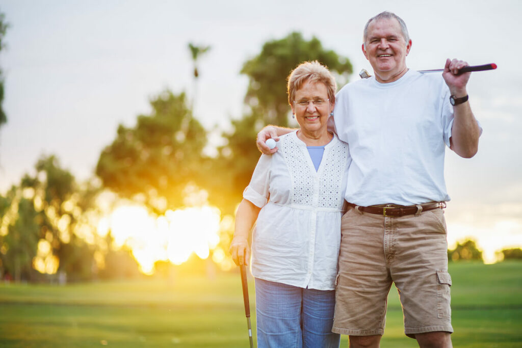 Avail Senior Living | Happy seniors holding putters on the golf course