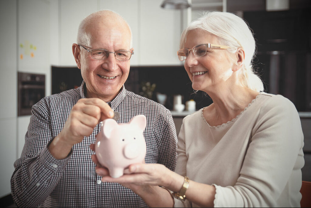 Avail Senior Living | Senior couple smiling and putting coin in piggybank