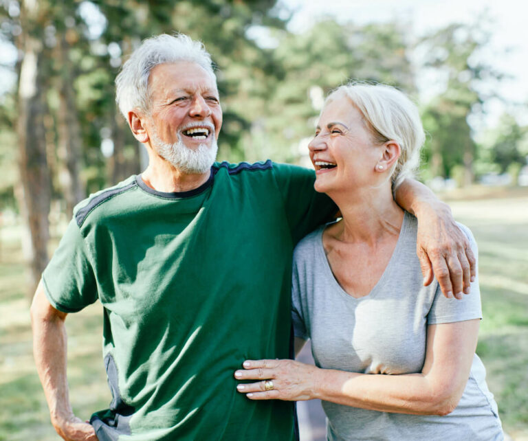 Avail Senior Living | Happy senior couple laughing while on a walk outside