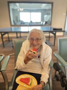 Avail Senior Living | Resident happily eating watermelon